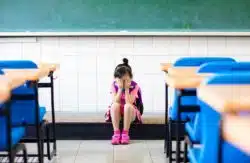 stressed girl student on floor of classroom