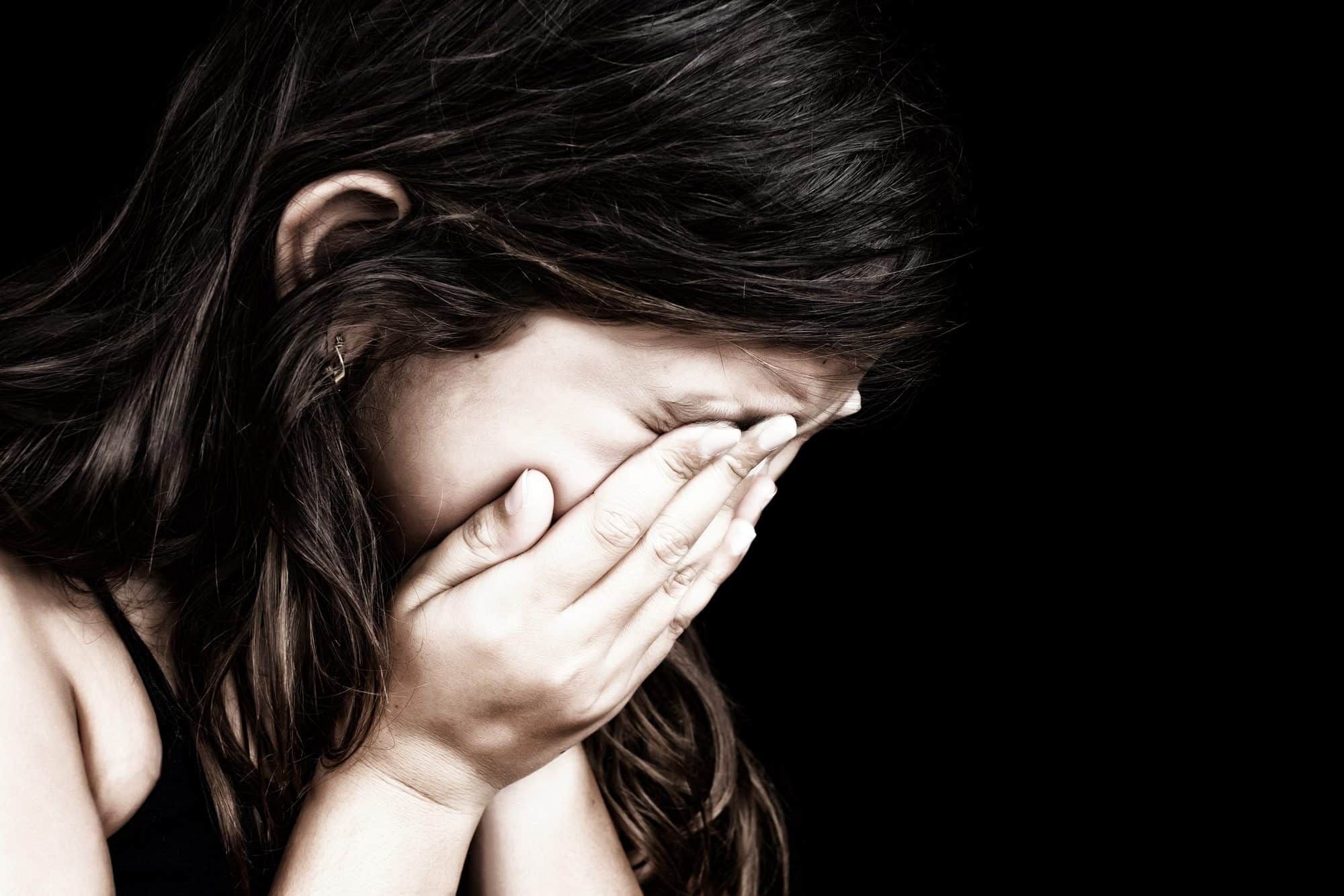 Girl crying with head in her hands