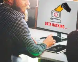 Man sees words Data Hacking on his computer screen