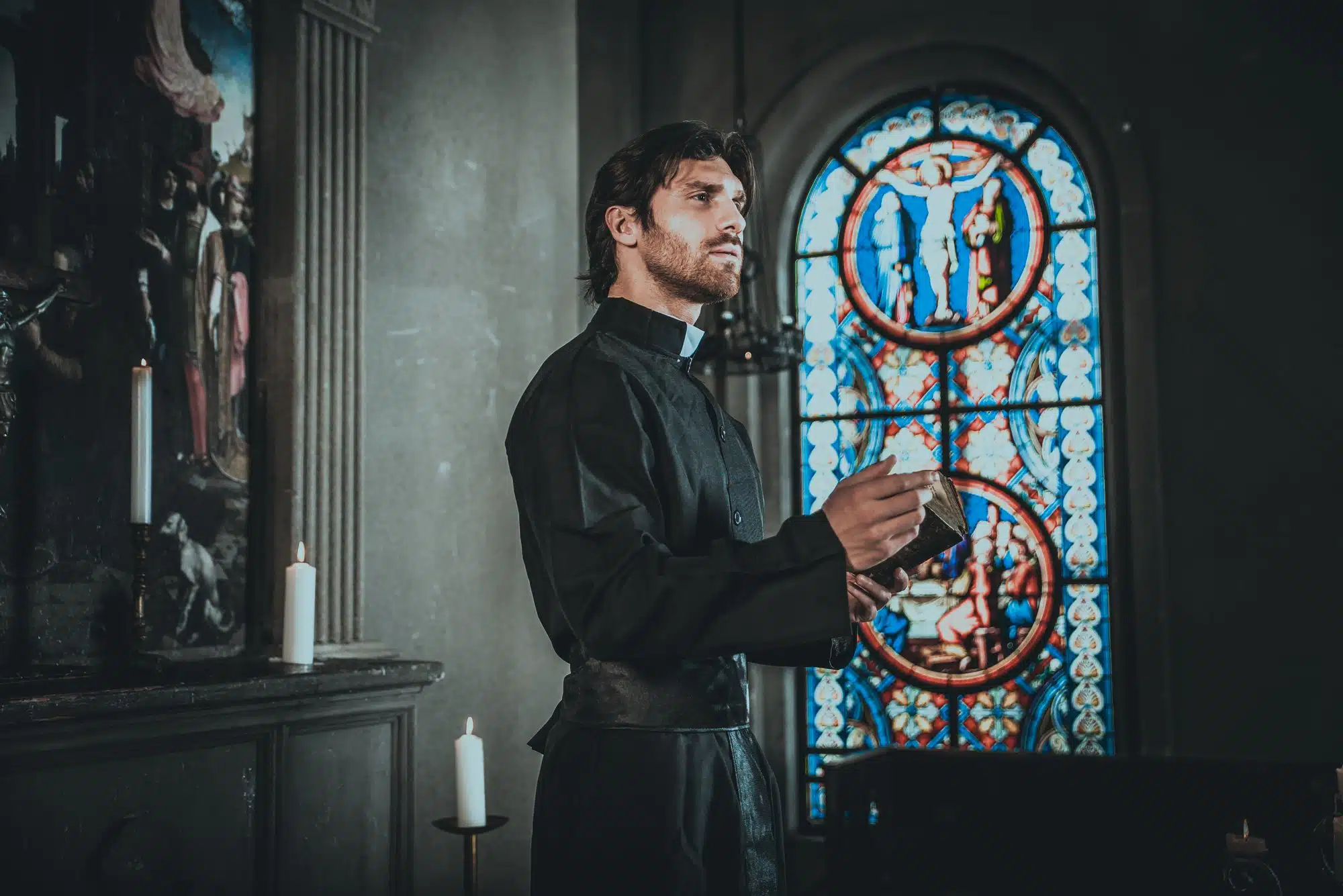 Priest holds open bible in church