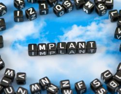 The word implant made with blocks with a blue sky background