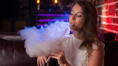 Young woman vaping at a bar