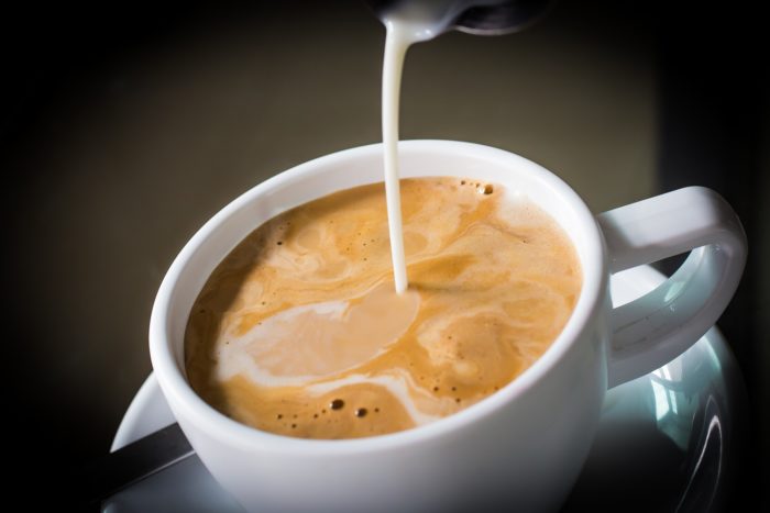 Coffee mate creamer being poured into a cup of coffee