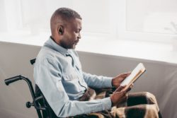 Man in wheelcahir reading paperwork to appeal a Social Security disability denial