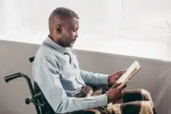 Man in wheelcahir reading paperwork to appeal a Social Security disability denial
