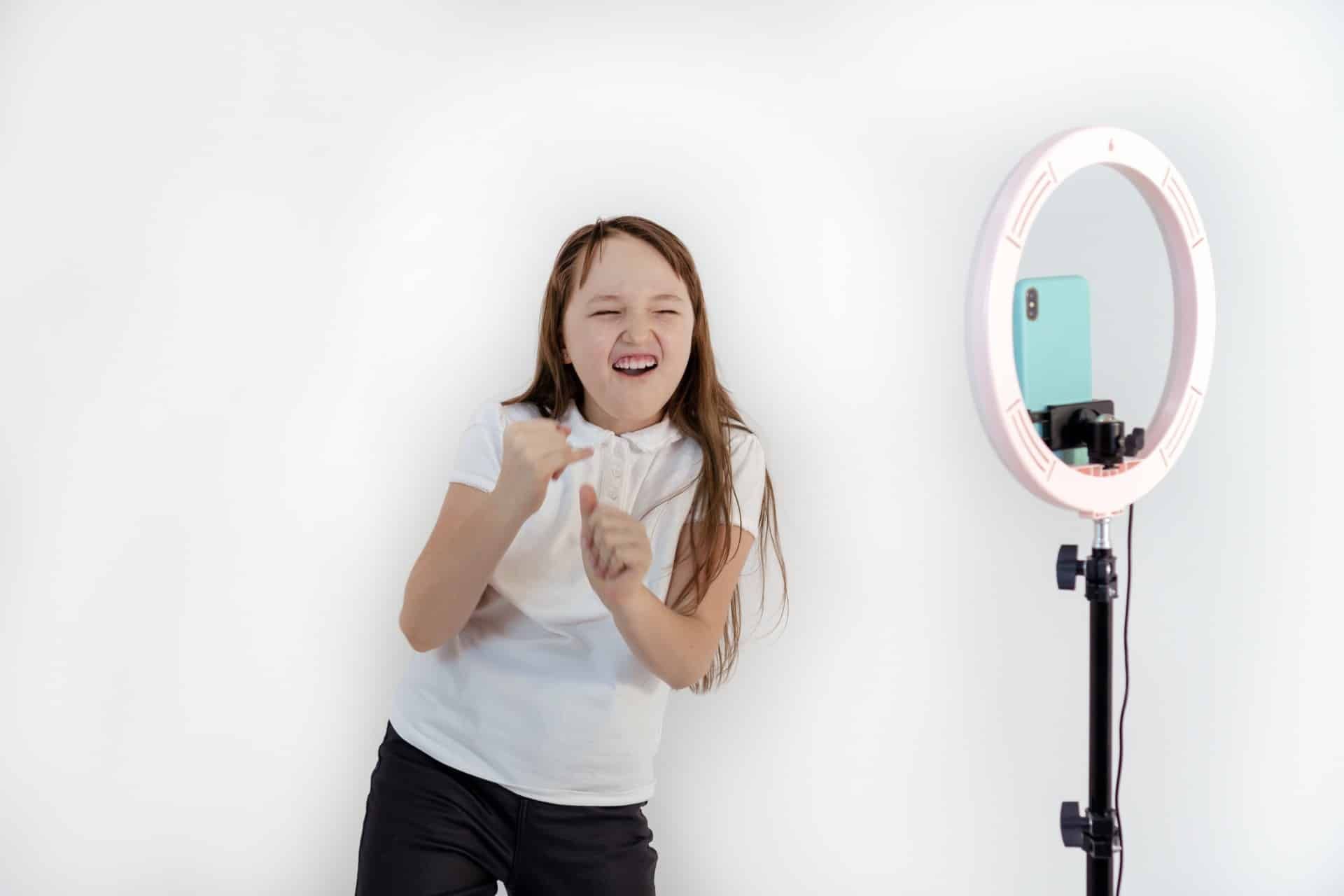 A teen makes a video with her smartphone and a ring light - TikTok users