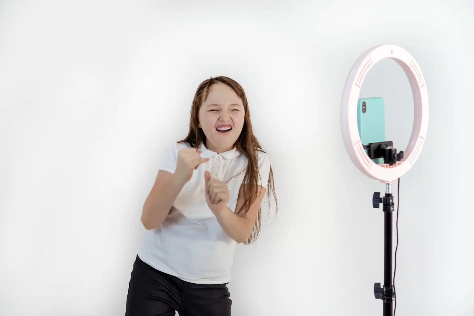 A teen makes a video with her smartphone and a ring light - TikTok users
