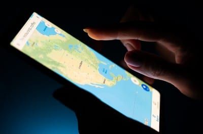 Closeup of a woman using Google maps in a dark room - Google location tracking