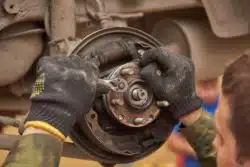 man-working-on-older-brakes-in-car