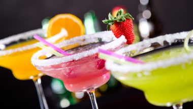 Three flavors of margarita in glasses with salt rims