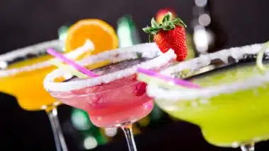 Three flavors of margarita in glasses with salt rims