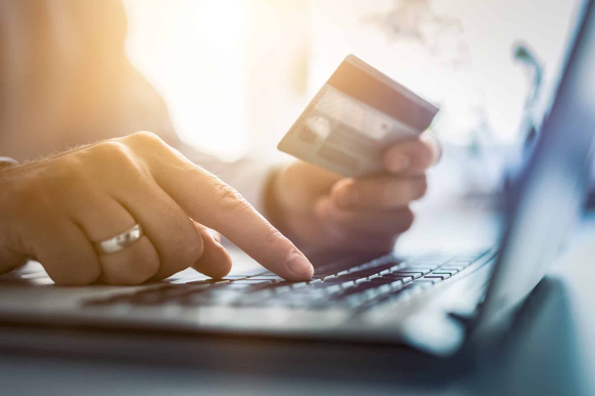 A person makes a purchase on their laptop using a credit card - upsell
