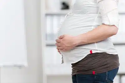 Pregnant woman holds her hands on her belly - pregnant worker rights