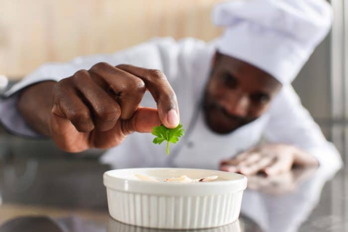 restaurant chef putting in last touch to meal
