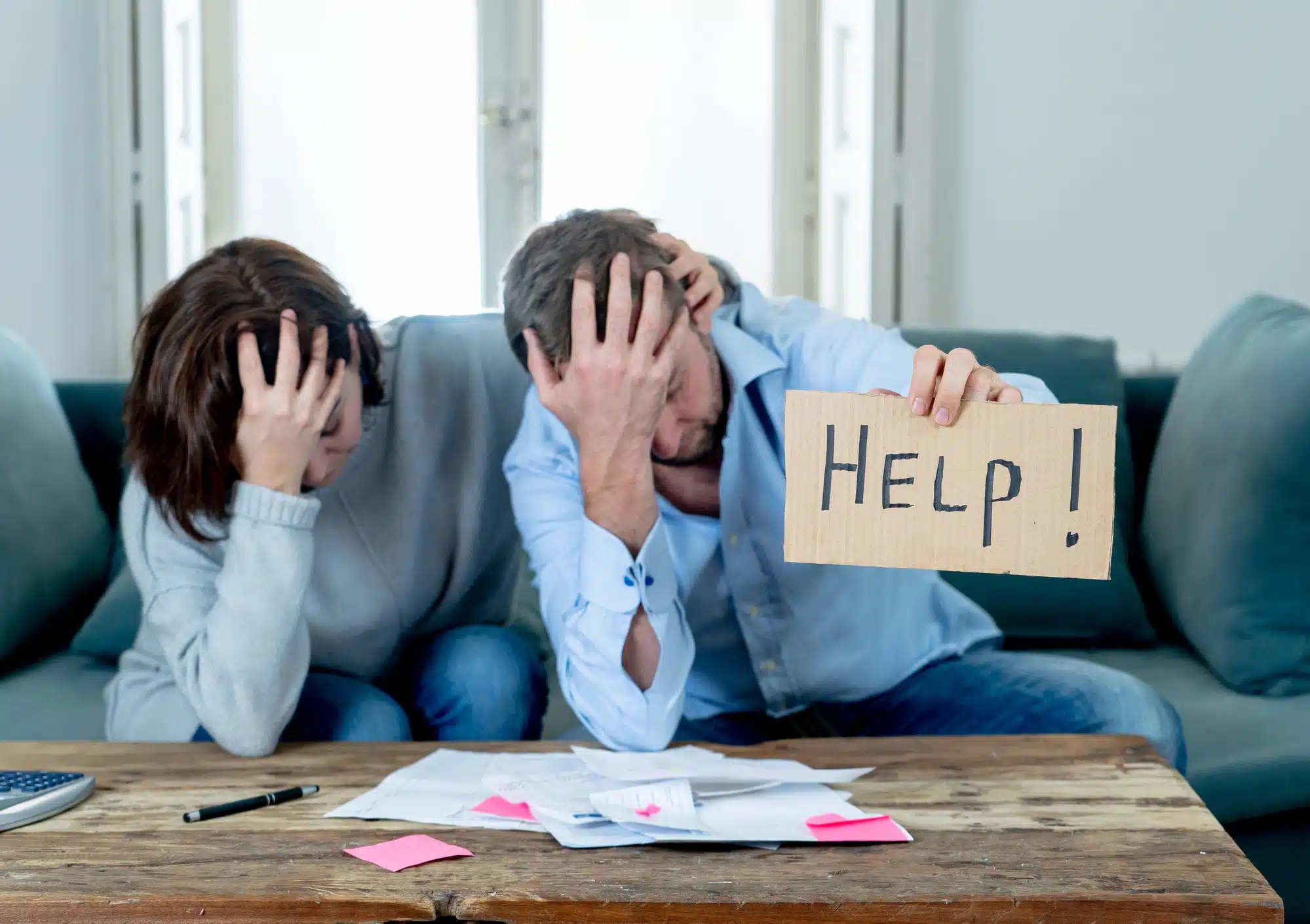 couple with help sign looking at bank statements