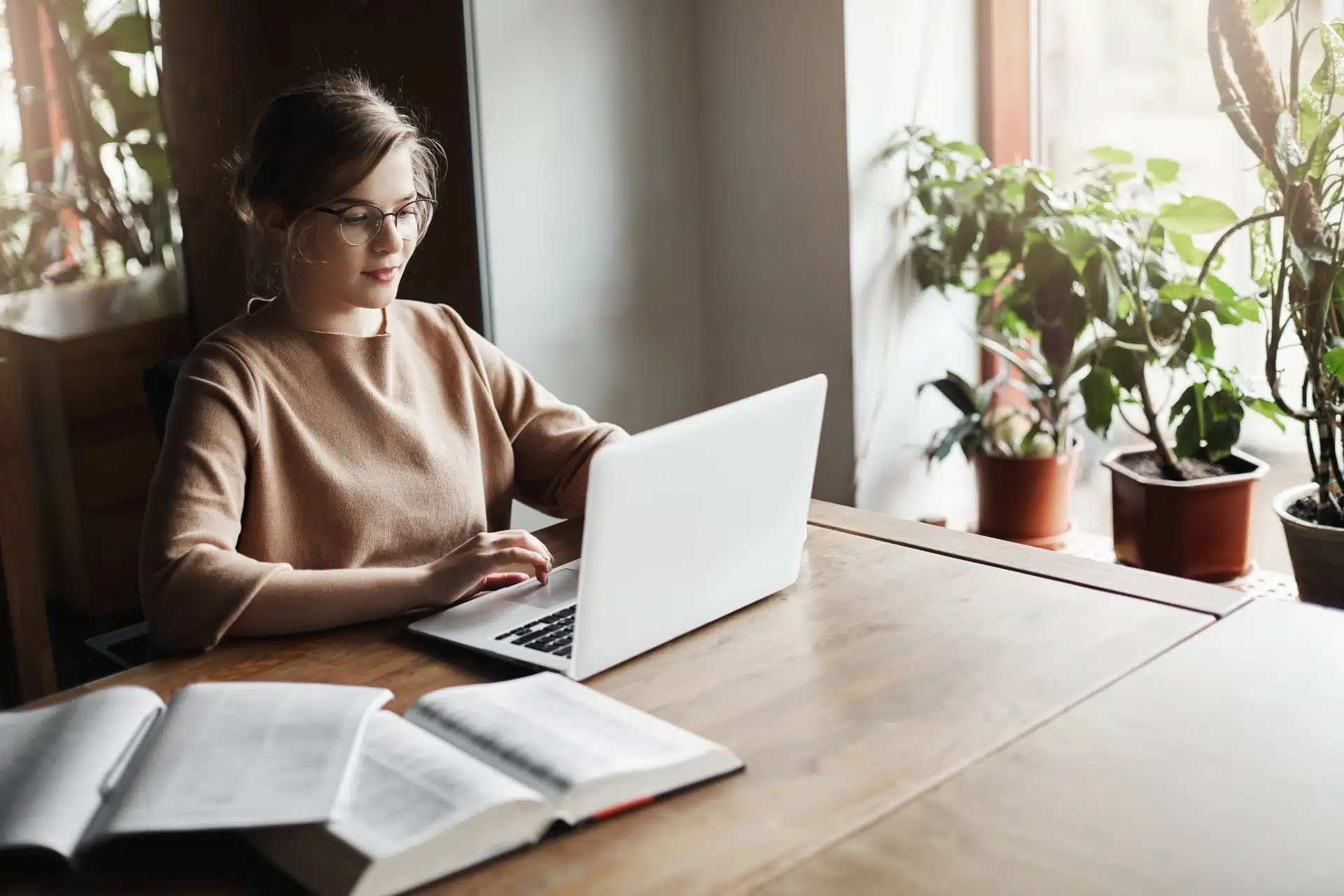 A female student works on a laptop with open books nearby - The word "Test!" is spelled out in red keys on a white keyboard - College Board AP Exams
