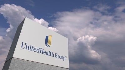 UnitedHealth Group sign under partly cloudy sky - AARP