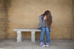 sad crying teenage college student on bench