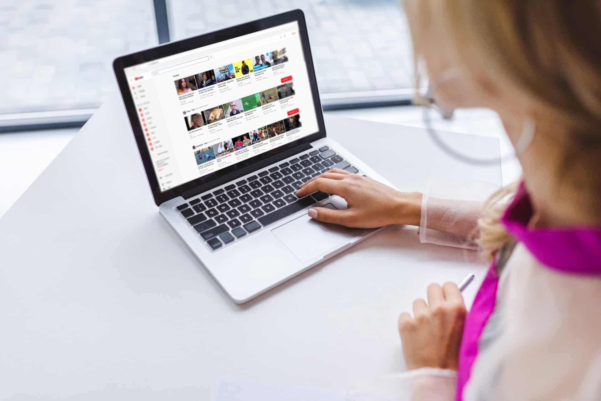 A woman watches YouTube on a laptop - YouTube content