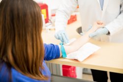 Closeup of arm being wiped with cotton ball prior to blood draw