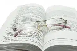 Eyeglasses sit atop open bible