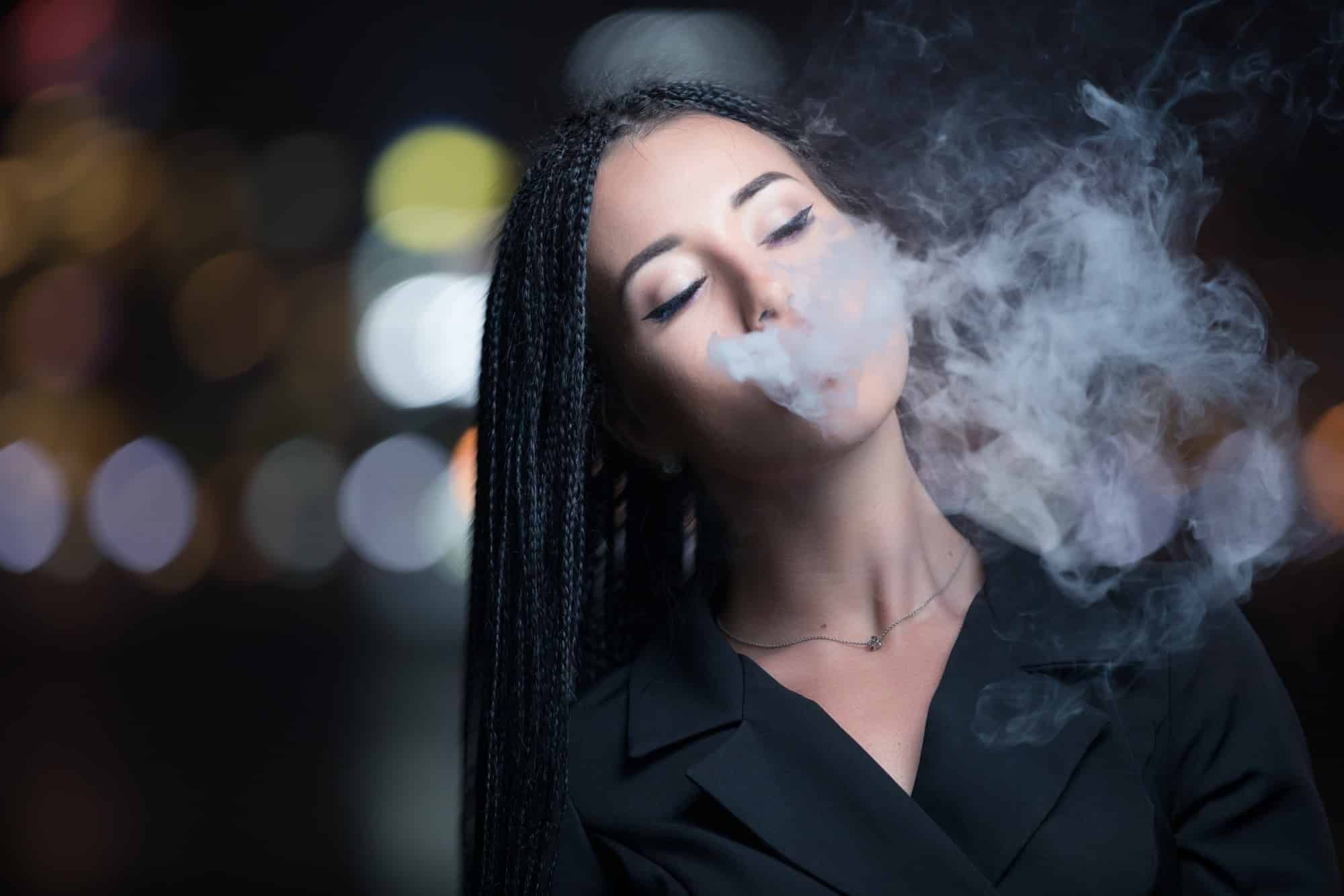 Woman walks and vapes in city