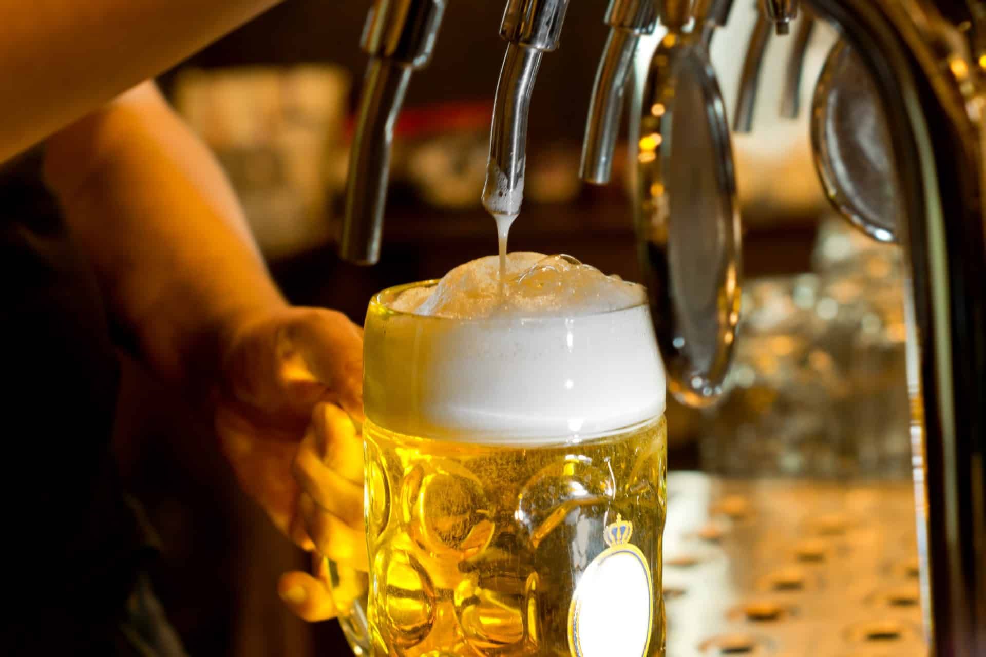 A bartender pours a beer from a tap - Olympia beer
