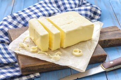 Butter lies on a cutting board with a knife and cloth napkin nearby - Pepperidge Farm Golden Butter Crackers