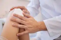 Closeup of doctor applying bandage to wound on knee