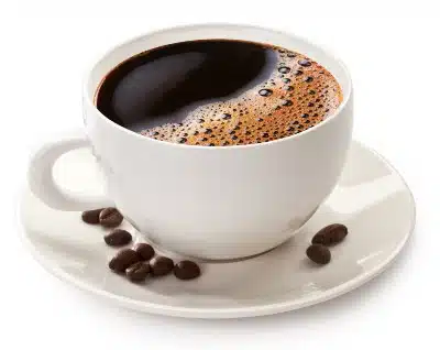 Coffee in a white cup on a white saucer with beans lying in it - Maxwell House