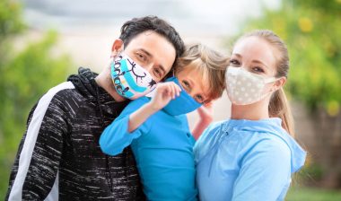 A man, woman and child wear face masks in various colors and patterns - sales tax