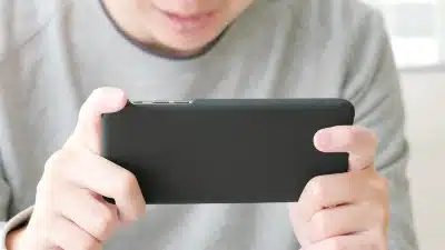 A guy plays a game on a smartphone - final fantasy