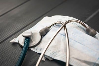 A surgical mask and stethoscope lie on a table - coronavirus outbreak