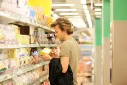 Man reading fruit snacks label regarding the Annie's Bunny Fruit Snacks class action lawsuit filed