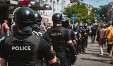 Police officers in helmets patrol at a protest - excessive force