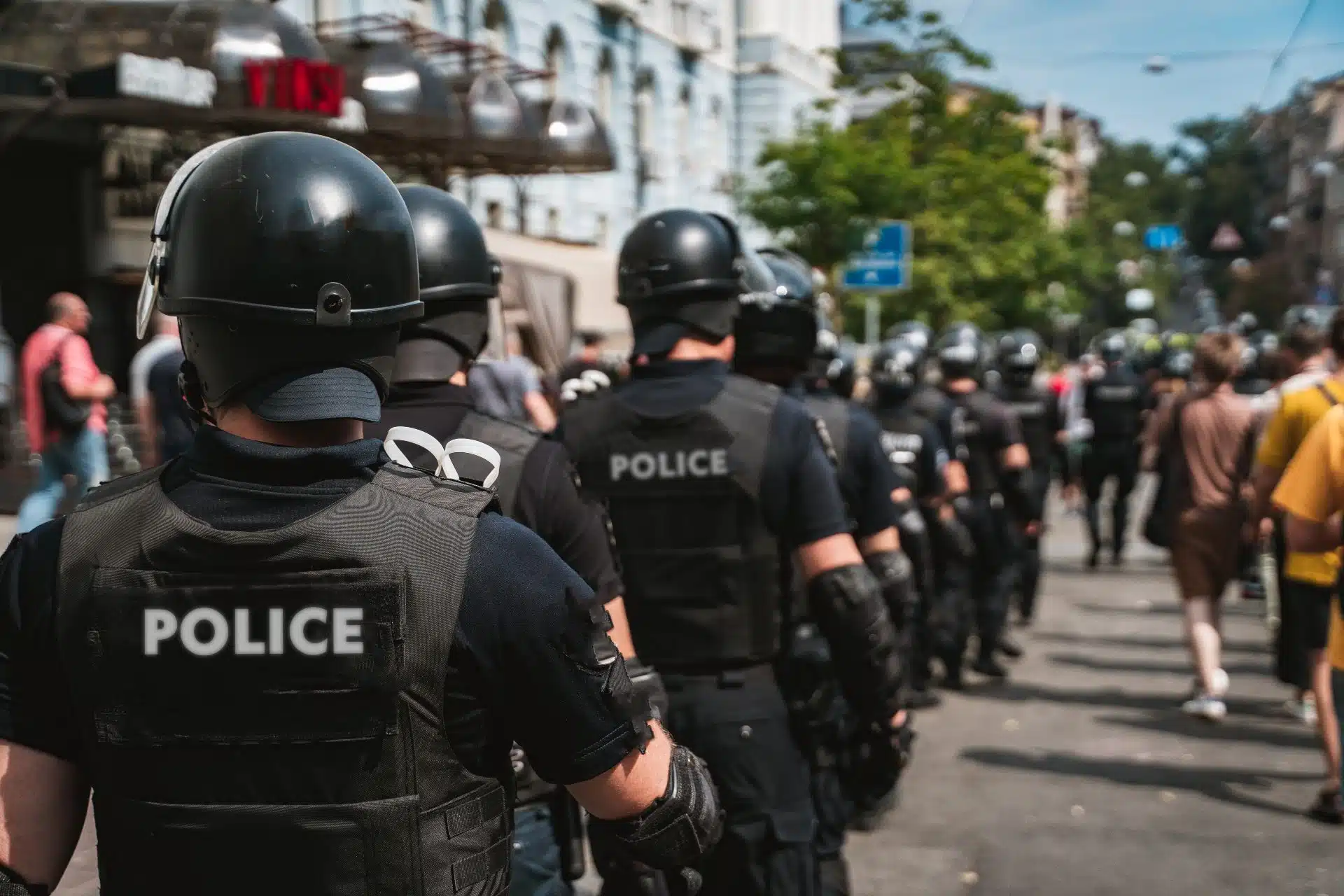 Police officers in helmets patrol at a protest - excessive force