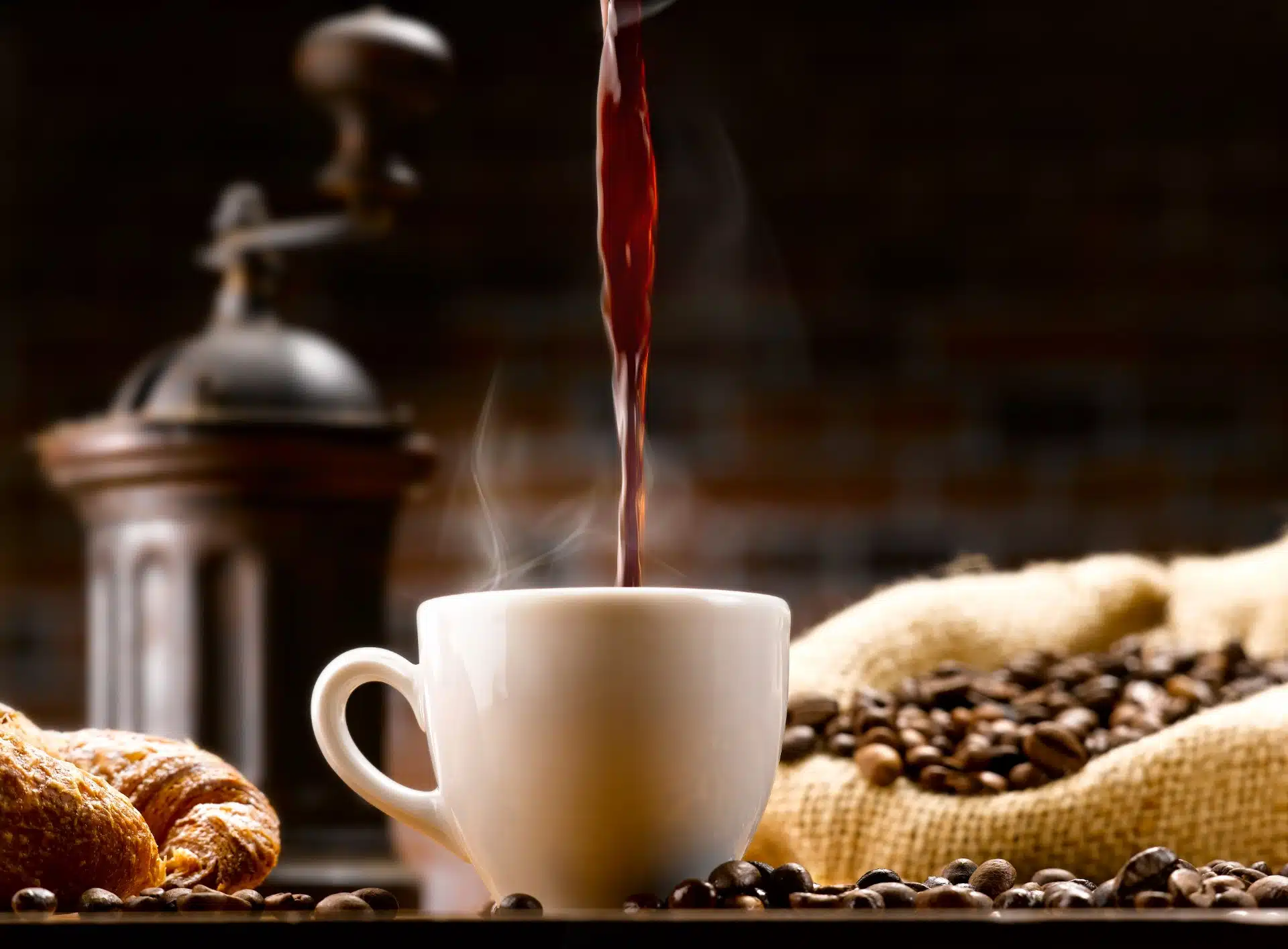 Coffee pours in to a coffee cup, with beans and a grinder in the background - Keurig single-serve coffee