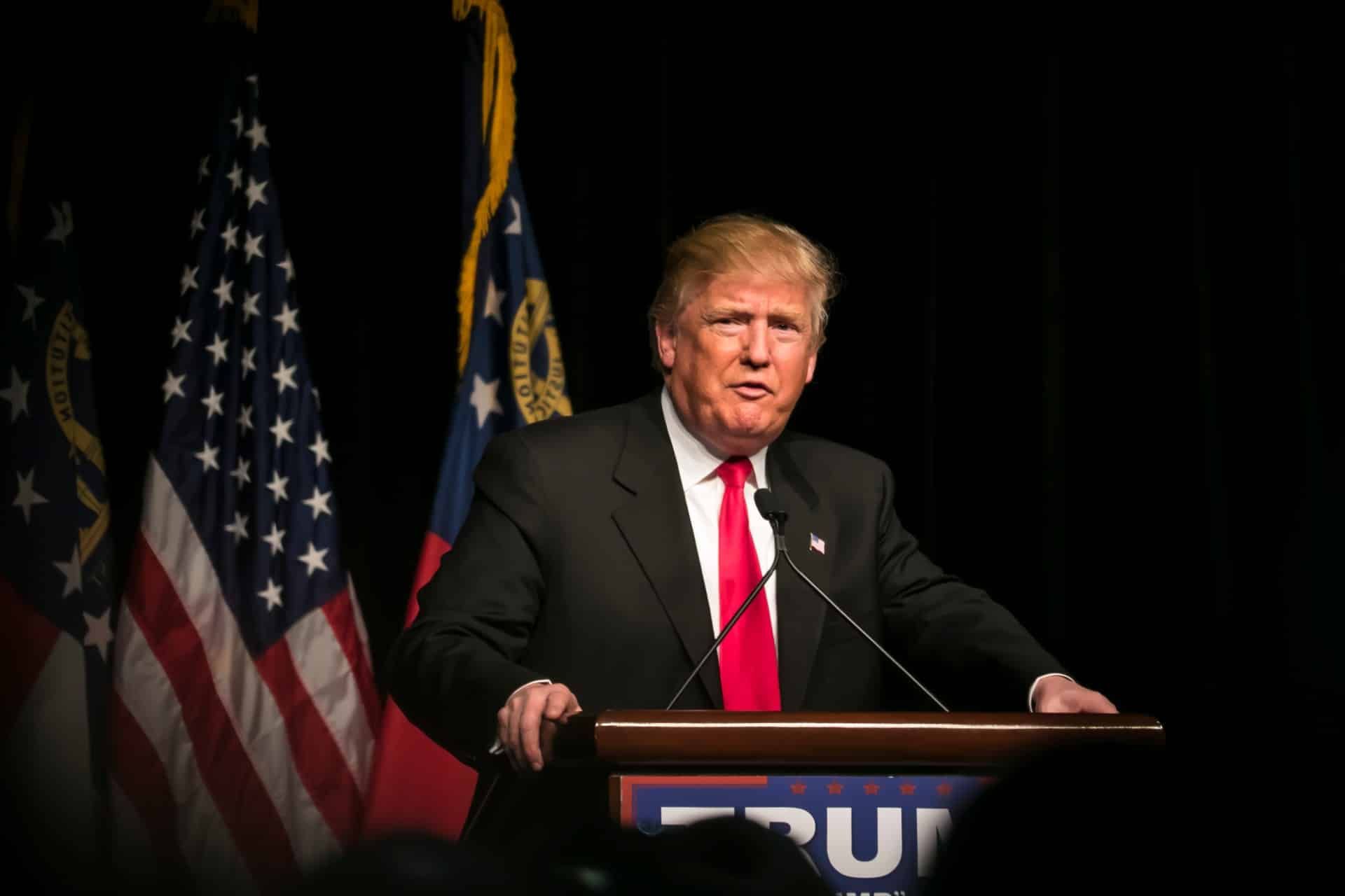President Donald Trump stands at a podium in front of flags - executive order