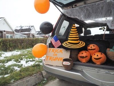 A vehicle is set up for trunk-or-treating, with snow on the ground - safety tips on halloween