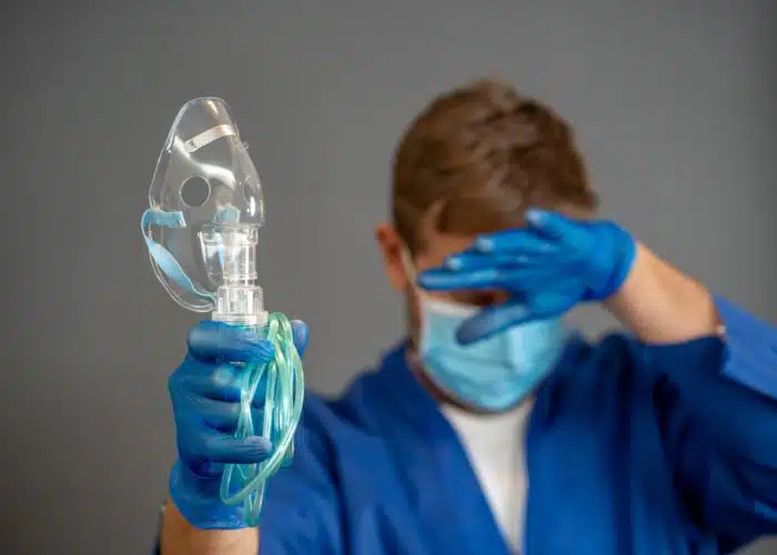 exhausted doctor holding a ventilator