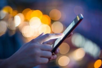 A woman's hands use a smartphone in the evening - android users