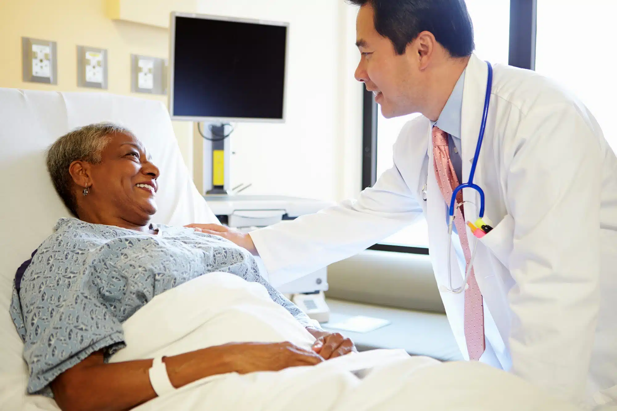 Male doctor talks to female hospital patient