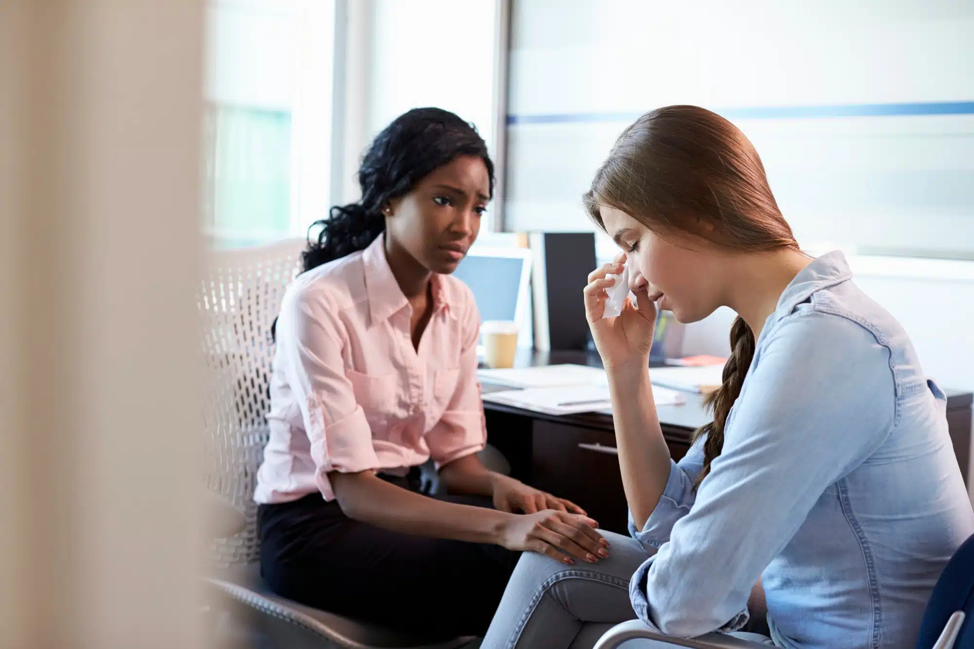 Female doctor consoles female patient