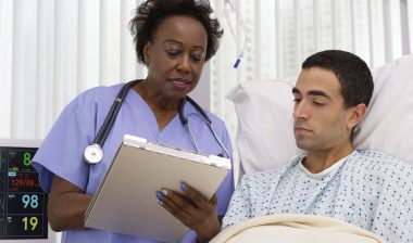 Female nurse goes over chart with male patient