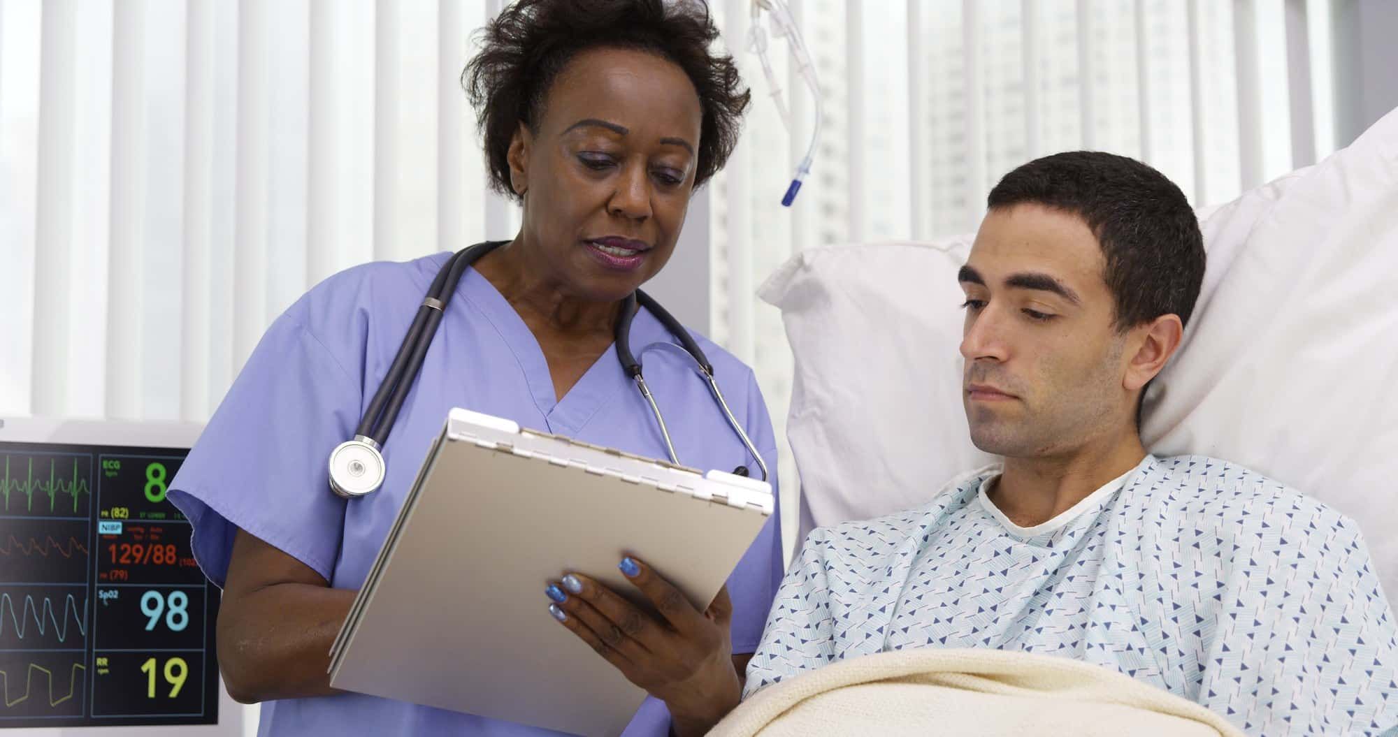 Female nurse goes over chart with male patient