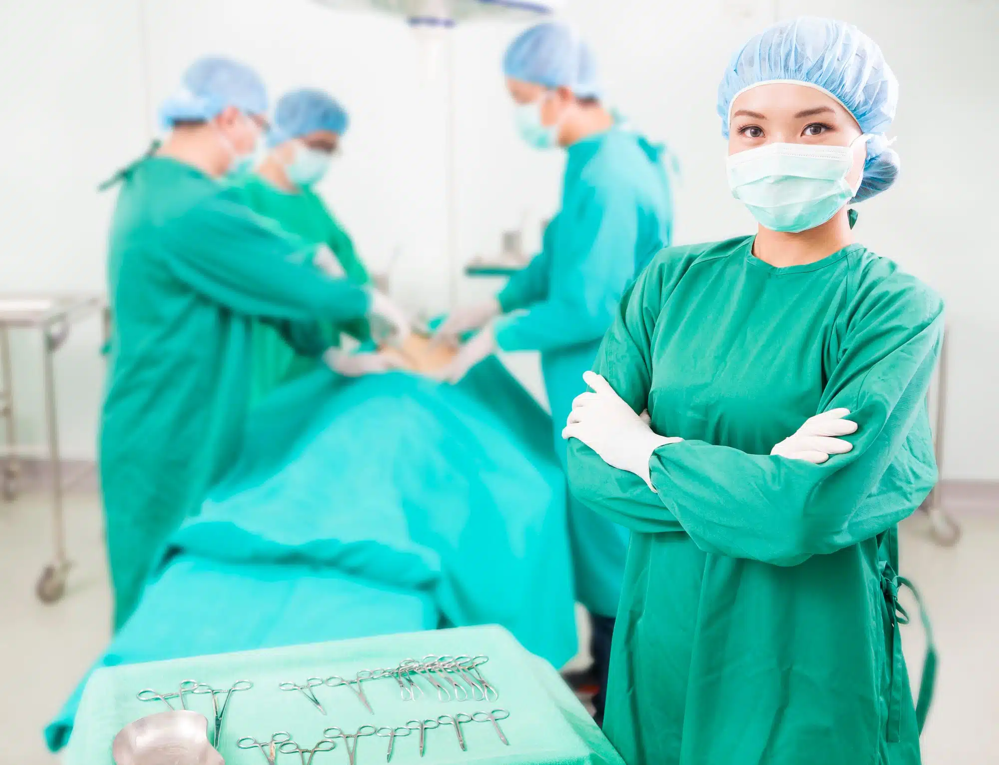Female surgeon stands next to table of surgical tools