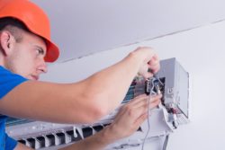 Man works on AC unit