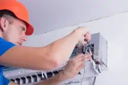 Man works on AC unit
