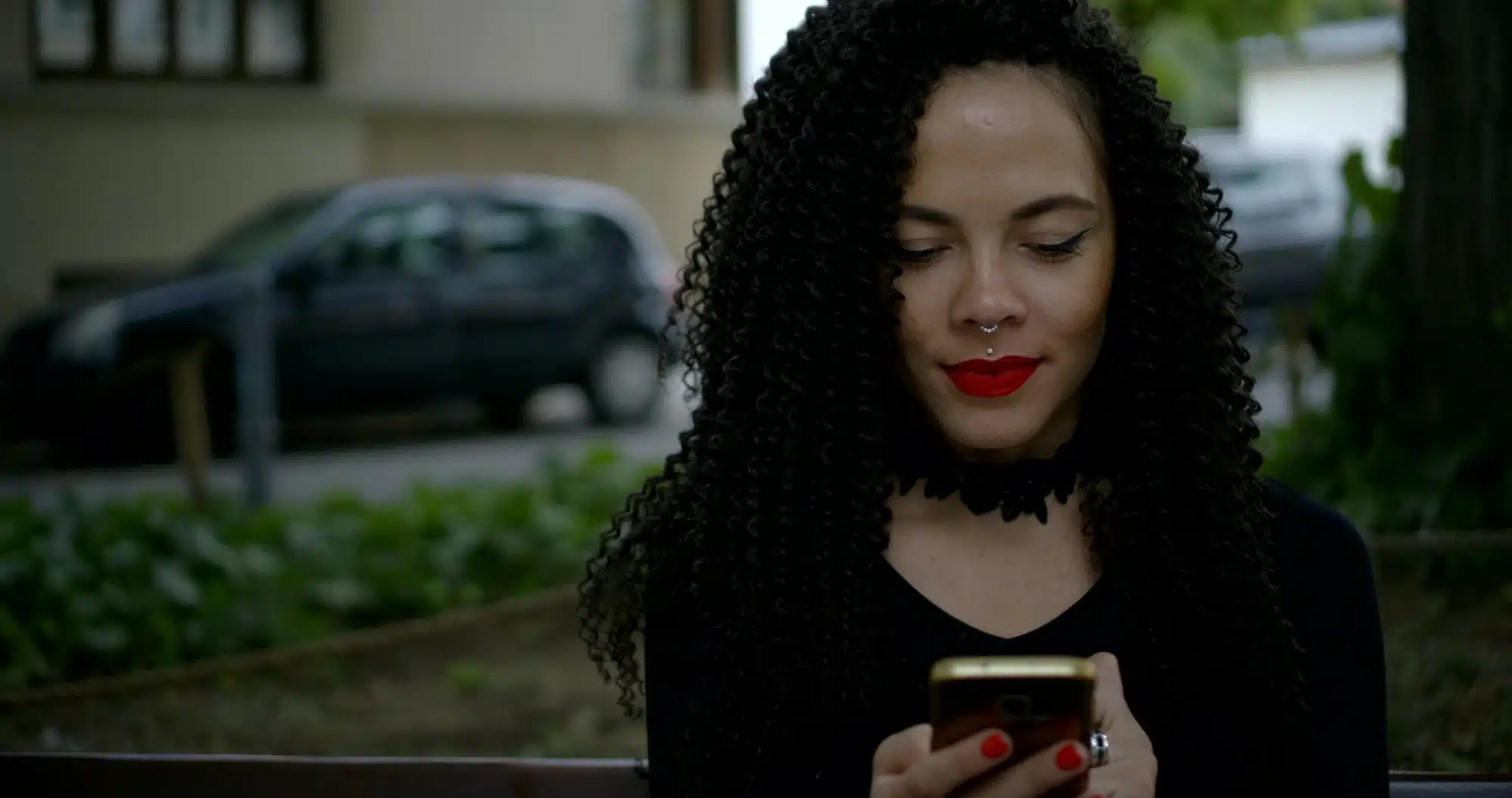 Young woman texting waits for ride outside