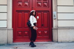 Young woman with backpack and a coffee waits for a ride